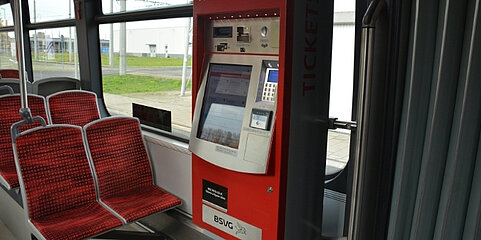 [Translate to English:] Roter Fahrscheinautomat in Straßenbahn